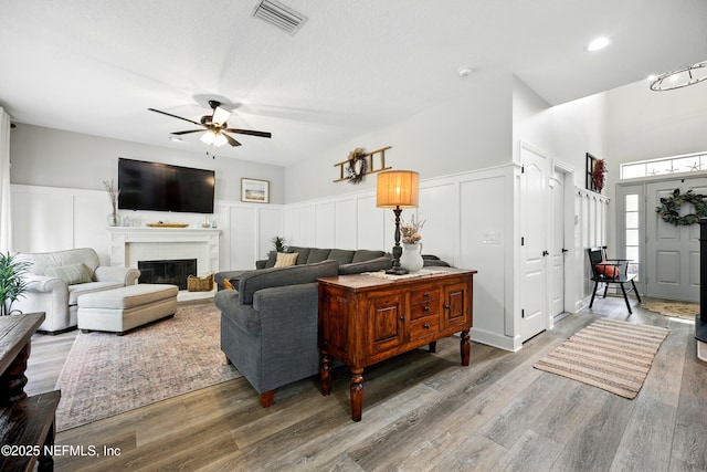 309 Elza Ln, Saint Augustine, FL 32086 - living area featuring a decorative wall, ceiling fan, a brick fireplace, wood finished floors, and wainscoting