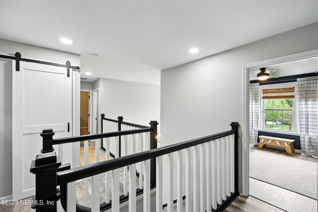 309 Elza Ln, Saint Augustine, FL 32086 - hallway featuring an upstairs landing, wood finished floors, a barn door, and recessed lighting