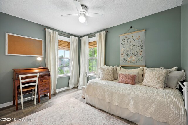 309 Elza Ln, Saint Augustine, FL 32086 - bedroom with wood finished floors, baseboards, a textured ceiling, and a ceiling fan