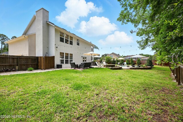 309 Elza Ln, Saint Augustine, FL 32086 - rear view of house featuring stucco siding, a patio area, and a chimney