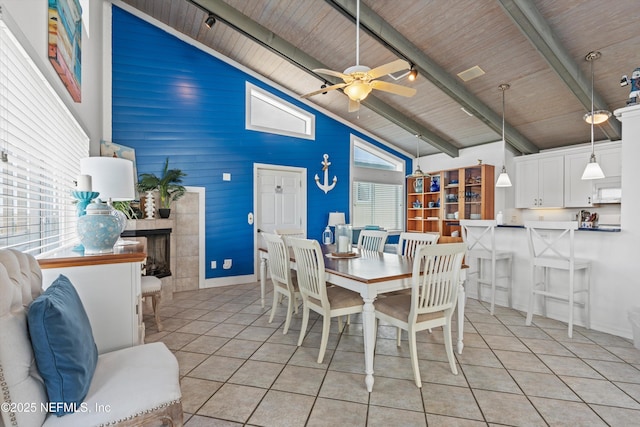 5473 Pelican Way, Saint Augustine, FL 32080 - dining space with high vaulted ceiling, light tile patterned floors, wood ceiling with exposed beams, a tile fireplace, and a ceiling fan