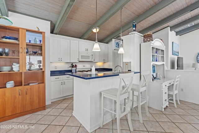 5473 Pelican Way, Saint Augustine, FL 32080 - kitchen with white appliances, wooden ceiling, dark countertops, light tile patterned flooring, and white cabinetry