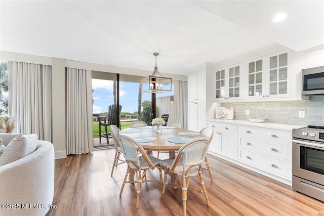 1185 Beach Walker Rd Unit 1185, Fernandina Beach, FL 32034 - dining room with healthy amount of natural light, light wood-style flooring, baseboards, and a chandelier