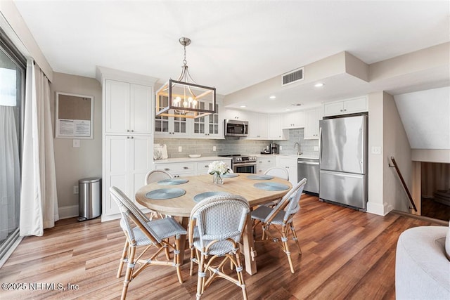 1185 Beach Walker Rd Unit 1185, Fernandina Beach, FL 32034 - dining space with baseboards, light wood-style floors, a chandelier, and recessed lighting