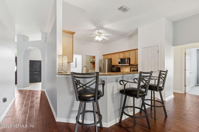 2000 Belhaven Dr, Orange Park, FL 32065 - kitchen with stainless steel refrigerator with ice dispenser, arched walkways, a ceiling fan, and dark wood-type flooring