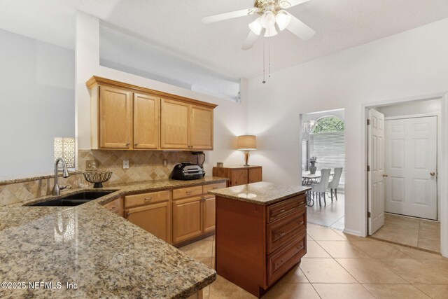 2000 Belhaven Dr, Orange Park, FL 32065 - kitchen featuring a sink, light stone countertops, backsplash, ceiling fan, and light tile patterned floors