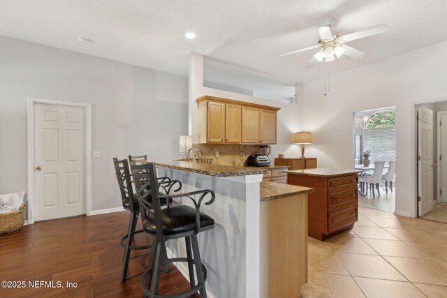 2000 Belhaven Dr, Orange Park, FL 32065 - kitchen with ceiling fan, tasteful backsplash, a kitchen breakfast bar, a sink, and a peninsula