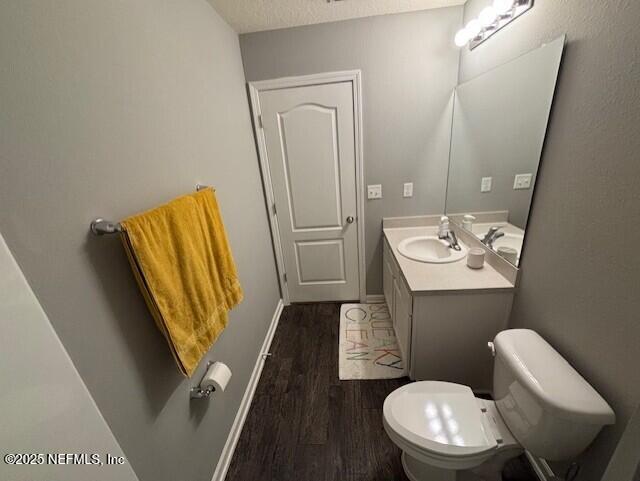 2358 Evening Oaks Ln, Green Cove Springs, FL 32043 - bathroom featuring wood finished floors, vanity, toilet, and baseboards