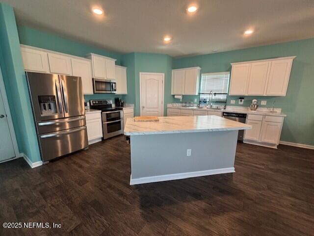 2358 Evening Oaks Ln, Green Cove Springs, FL 32043 - kitchen featuring appliances with stainless steel finishes, white cabinetry, light stone countertops, dark wood finished floors, and recessed lighting