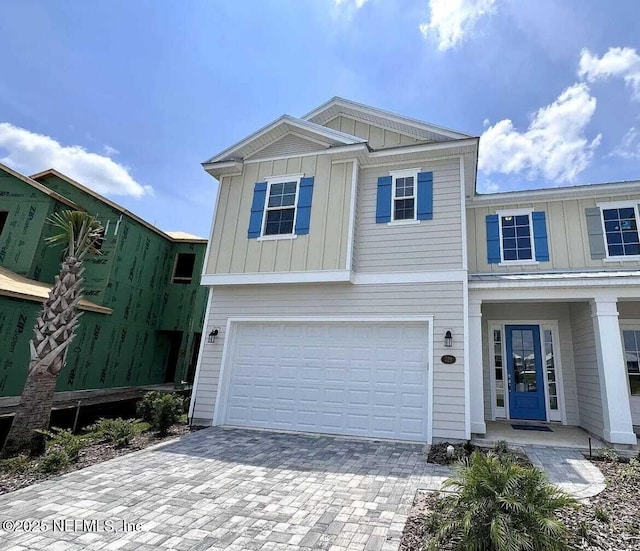 329 Rum Runner Way, Saint Johns, FL 32259 - view of front facade with board and batten siding, a garage, and decorative driveway