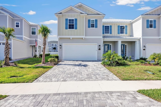 329 Rum Runner Way, Saint Johns, FL 32259 - view of front facade with board and batten siding, an attached garage, decorative driveway, and a front lawn