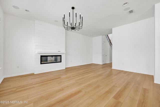 329 Rum Runner Way, Saint Johns, FL 32259 - unfurnished living room featuring a chandelier, a large fireplace, light wood-style flooring, and baseboards
