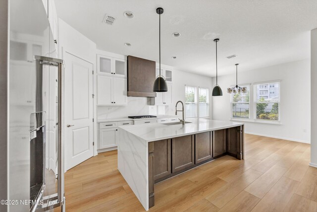 329 Rum Runner Way, Saint Johns, FL 32259 - kitchen featuring a sink, light wood-style flooring, light countertops, white cabinetry, and glass insert cabinets