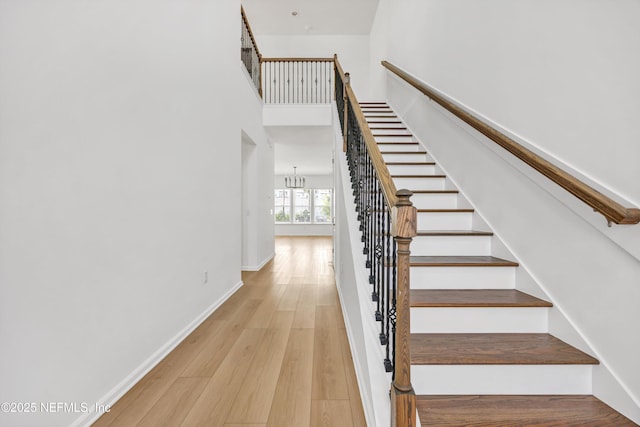 329 Rum Runner Way, Saint Johns, FL 32259 - stairs featuring wood finished floors, a towering ceiling, a chandelier, and baseboards