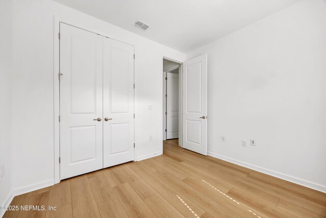329 Rum Runner Way, Saint Johns, FL 32259 - unfurnished bedroom with light wood-style flooring, baseboards, and a closet
