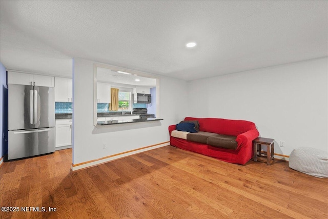 381 Bird Rd, Jacksonville, FL 32218 - living area featuring light wood-style floors, recessed lighting, baseboards, and a textured ceiling