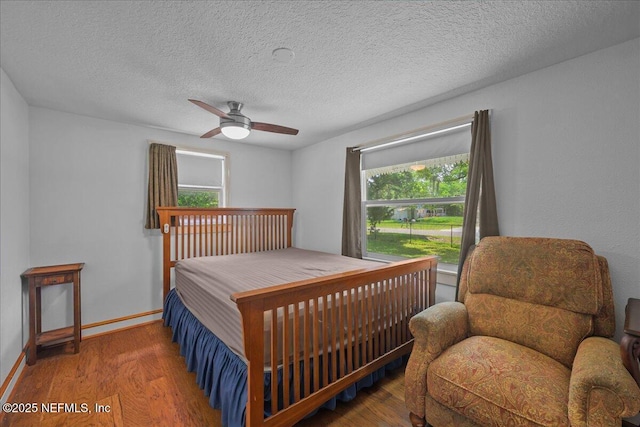 381 Bird Rd, Jacksonville, FL 32218 - bedroom with wood finished floors, a ceiling fan, baseboards, and a textured ceiling