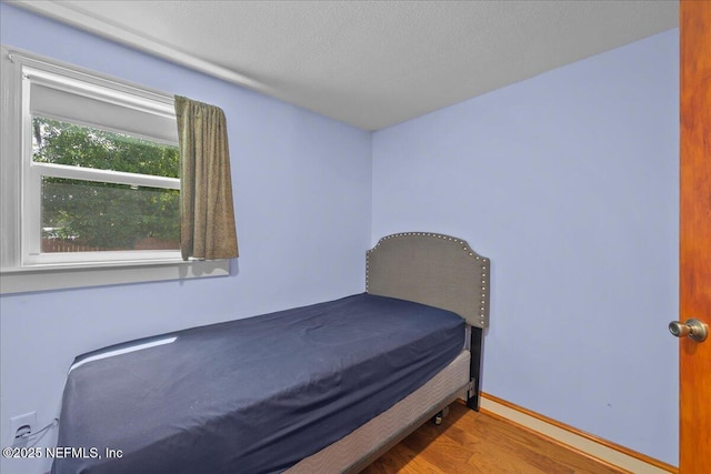 381 Bird Rd, Jacksonville, FL 32218 - bedroom with wood finished floors, a textured ceiling, and baseboards