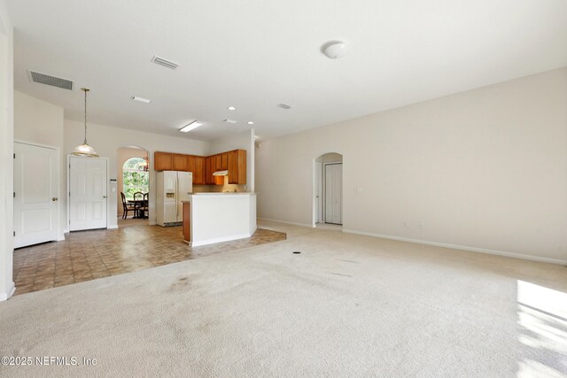 372 Johns Creek Pkwy, Saint Augustine, FL 32092 - unfurnished living room featuring arched walkways, baseboards, and light colored carpet