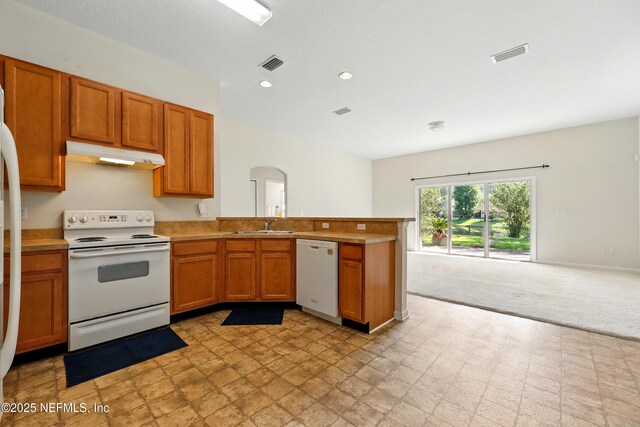 372 Johns Creek Pkwy, Saint Augustine, FL 32092 - kitchen with white appliances, under cabinet range hood, arched walkways, open floor plan, and brown cabinetry