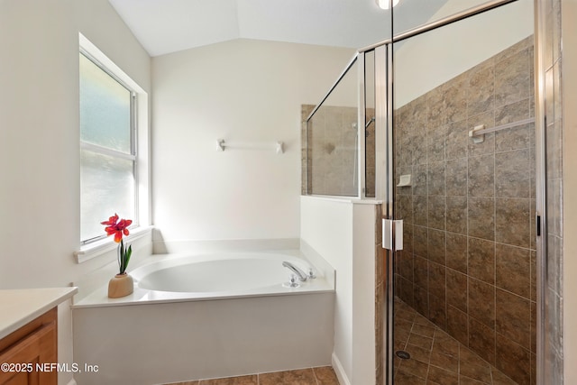 372 Johns Creek Pkwy, Saint Augustine, FL 32092 - full bath featuring a garden tub, vanity, a shower stall, vaulted ceiling, and tile patterned floors
