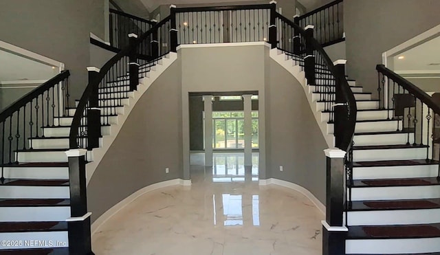 144 N Prairie Lakes Dr, Saint Augustine, FL 32084 - stairway featuring a towering ceiling, marble tiled flooring, and baseboards