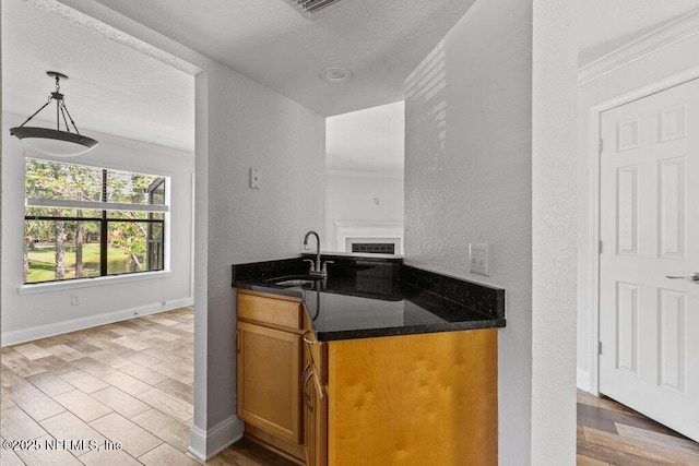 833 Shoreline Cir, Ponte Vedra Beach, FL 32082 - kitchen featuring a sink, crown molding, brown cabinets, light wood finished floors, and baseboards