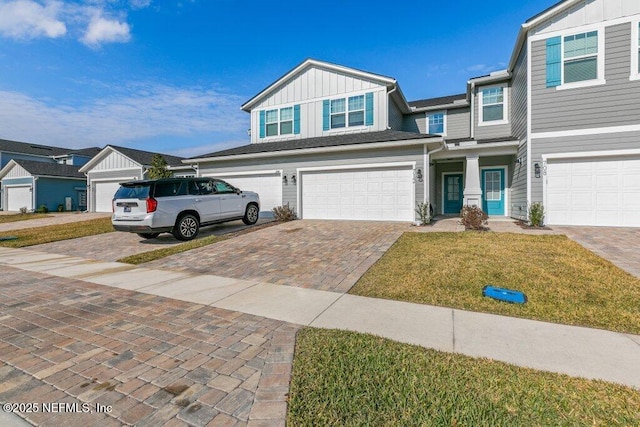 712 Cherry Elm Dr, Saint Augustine, FL 32092 - view of front facade featuring board and batten siding, an attached garage, a front yard, and decorative driveway