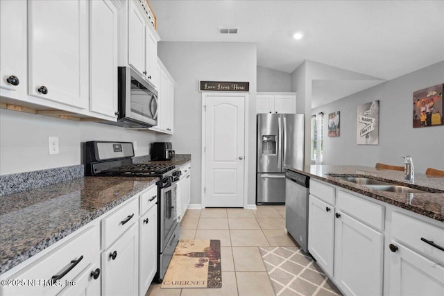 86815 Iron Rail Ct, Yulee, FL 32097 - kitchen with stainless steel appliances, a sink, white cabinets, lofted ceiling, and dark stone countertops