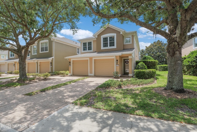 11889 Surfbird Cir Unit 10F, Jacksonville, FL 32256 - traditional-style home featuring a garage, stucco siding, and decorative driveway