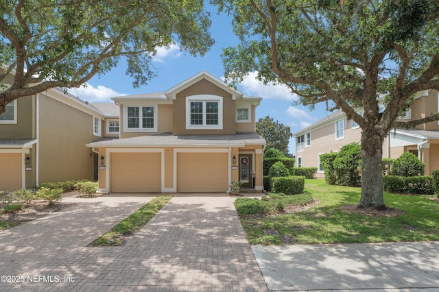 11889 Surfbird Cir Unit 10F, Jacksonville, FL 32256 - traditional-style home featuring an attached garage, stucco siding, and decorative driveway