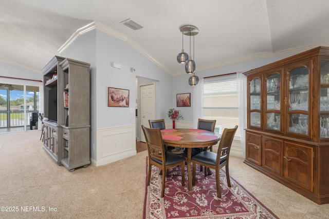 11889 Surfbird Cir Unit 10F, Jacksonville, FL 32256 - dining room with light colored carpet, vaulted ceiling, a wainscoted wall, crown molding, and a textured ceiling