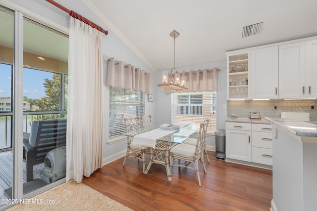 11889 Surfbird Cir Unit 10F, Jacksonville, FL 32256 - dining area featuring a chandelier, dark wood-type flooring, lofted ceiling, crown molding, and baseboards