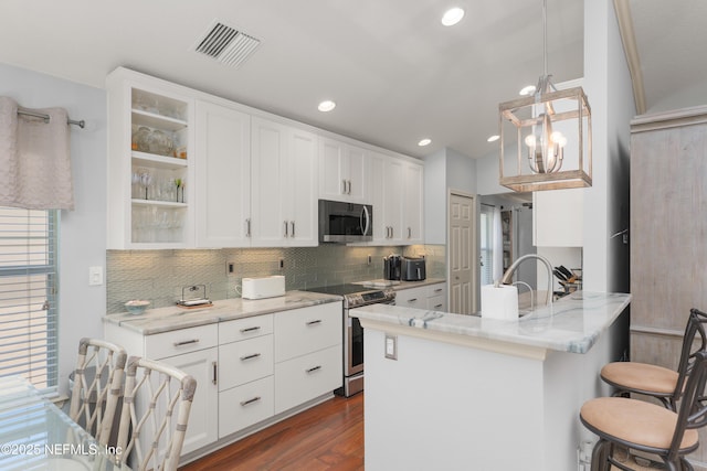 11889 Surfbird Cir Unit 10F, Jacksonville, FL 32256 - kitchen with appliances with stainless steel finishes, glass insert cabinets, dark wood-type flooring, a kitchen breakfast bar, and white cabinets