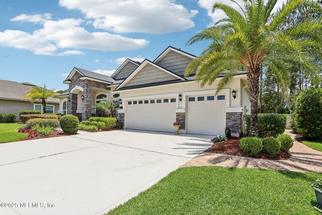 33 Tinker Ct, Fruit Cove, FL 32259 - craftsman house with stone siding, an attached garage, concrete driveway, and a front yard