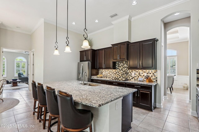 33 Tinker Ct, Fruit Cove, FL 32259 - kitchen with a sink, stainless steel fridge with ice dispenser, dark brown cabinets, arched walkways, and light tile patterned floors