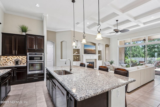 33 Tinker Ct, Fruit Cove, FL 32259 - kitchen featuring a sink, open floor plan, a glass covered fireplace, light tile patterned flooring, and crown molding