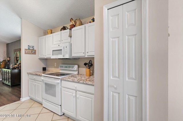 589 Prosperity Lake Dr, Saint Augustine, FL 32092 - kitchen featuring white appliances, white cabinetry, a textured ceiling, light tile patterned flooring, and light stone countertops
