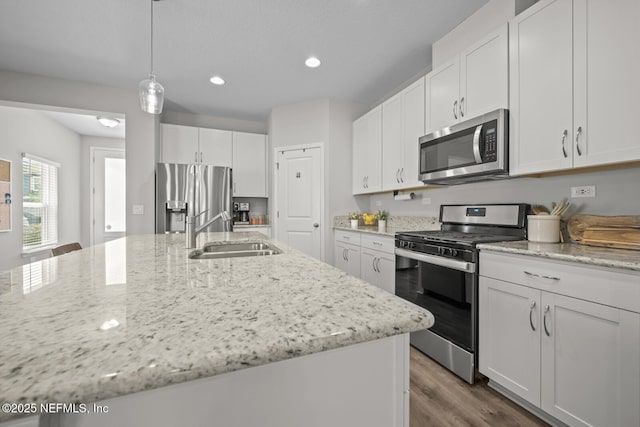 149 Ferndale Way, Saint Augustine, FL 32092 - kitchen featuring stainless steel appliances, a sink, white cabinetry, wood finished floors, and recessed lighting