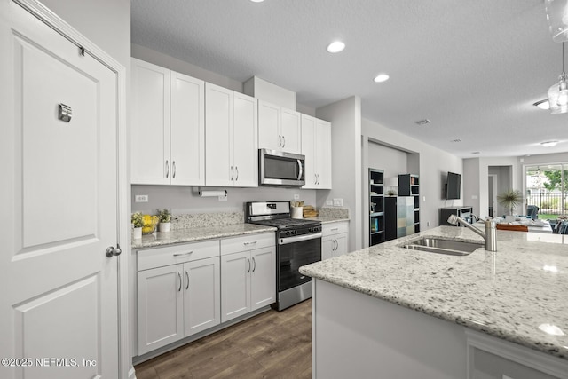 149 Ferndale Way, Saint Augustine, FL 32092 - kitchen featuring stainless steel appliances, a sink, dark wood-style flooring, white cabinets, and a textured ceiling