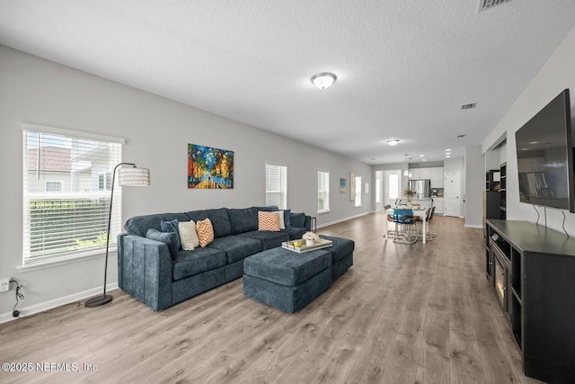 149 Ferndale Way, Saint Augustine, FL 32092 - living area with light wood finished floors, baseboards, and a textured ceiling