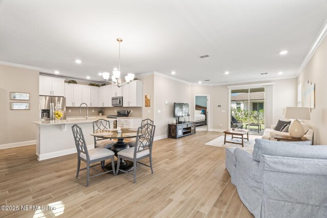 121 Thistleton Way, Saint Augustine, FL 32092 - dining room featuring recessed lighting, a chandelier, baseboards, crown molding, and light wood finished floors