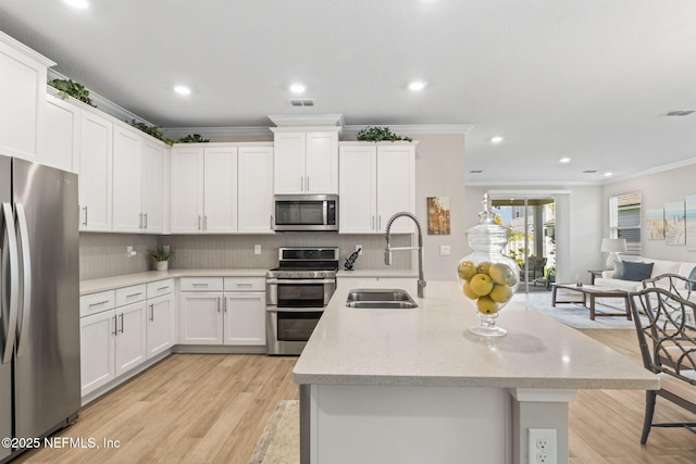 121 Thistleton Way, Saint Augustine, FL 32092 - kitchen with stainless steel appliances, a sink, ornamental molding, backsplash, and light wood finished floors