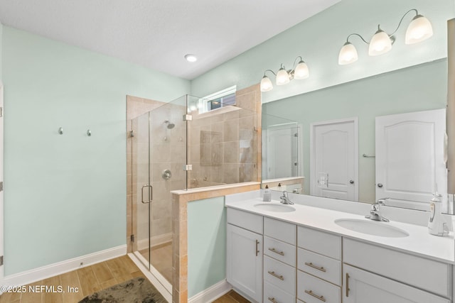 121 Thistleton Way, Saint Augustine, FL 32092 - bathroom with a shower stall, double vanity, wood finished floors, and baseboards