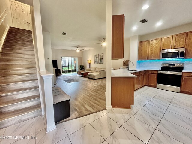 12301 Kernan Forest Blvd Unit 1905, Jacksonville, FL 32225 - kitchen with appliances with stainless steel finishes, a sink, light marble finish floors, open floor plan, and a peninsula