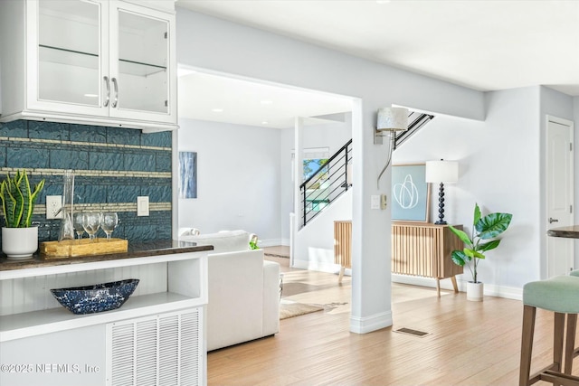 415 Seminole Rd, Atlantic Beach, FL 32233 - kitchen with light wood finished floors, tasteful backsplash, glass insert cabinets, white cabinetry, and baseboards