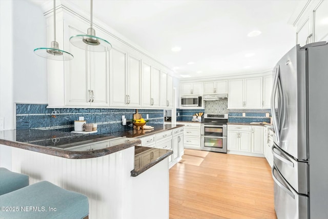 415 Seminole Rd, Atlantic Beach, FL 32233 - kitchen featuring stainless steel appliances, white cabinets, a peninsula, backsplash, and light wood-style floors