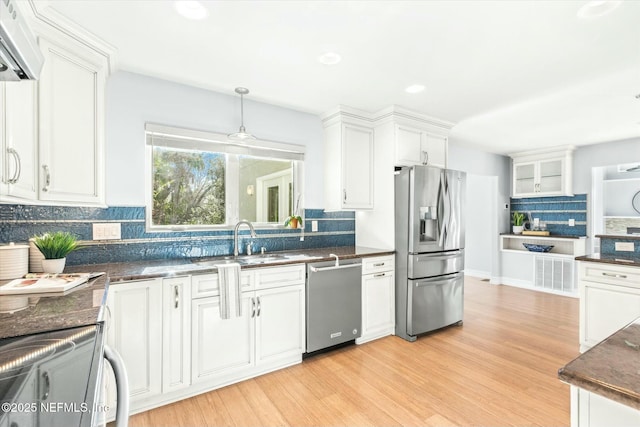 415 Seminole Rd, Atlantic Beach, FL 32233 - kitchen with appliances with stainless steel finishes, a sink, tasteful backsplash, white cabinets, and light wood-style floors