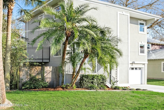 415 Seminole Rd, Atlantic Beach, FL 32233 - view of home's exterior with an attached garage, stucco siding, driveway, a lawn, and stairs