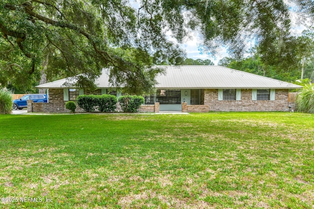 122 Raintree Woods Trl, Palatka, FL 32177 - view of front facade with a front lawn, metal roof, and brick siding